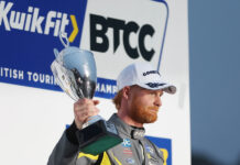 Josh Cook celebrates with a trophy on the podium